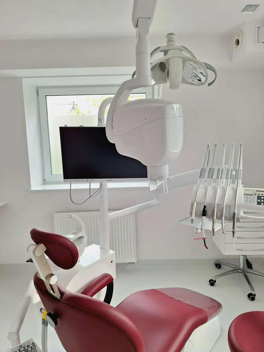 Unit stomatologiczny z lampą i instrumentami w gabinecie zabiegowym Sana Dente
